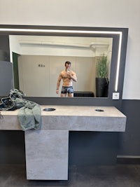 a man is standing in front of a mirror in an office
